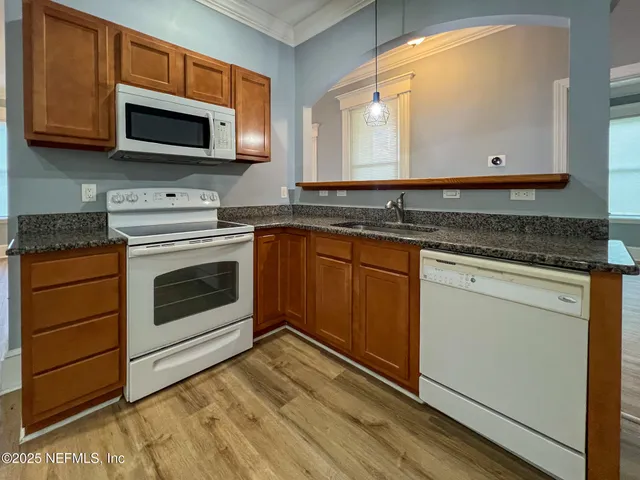 a kitchen with granite countertop a stove microwave and sink