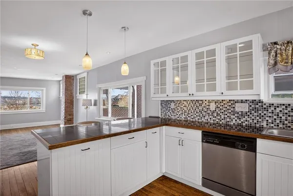 a kitchen with granite countertop a sink and a white cabinets