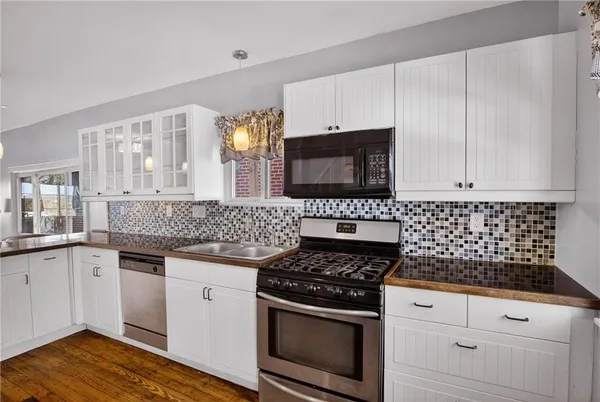 a kitchen with granite countertop white cabinets and appliances