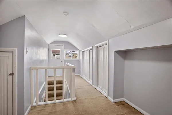 a view of a hallway with wooden floor and entryway
