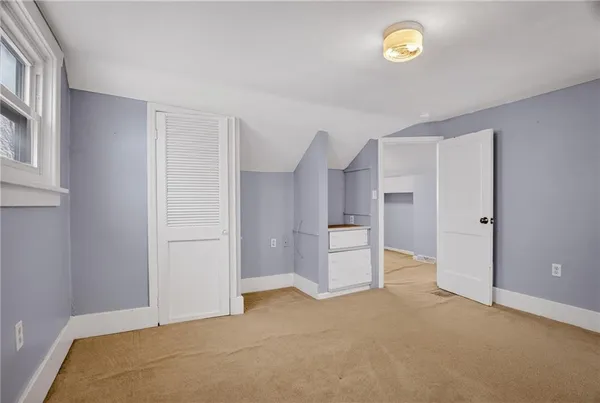 an empty room with closet and windows