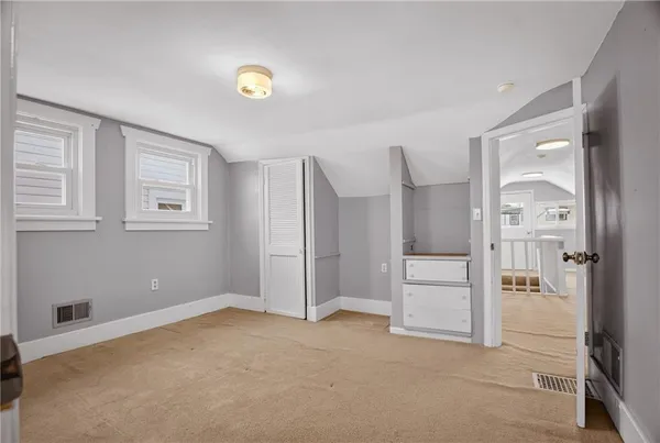 a view of an empty room with a cabinet and a window