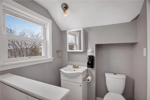 a bathroom with a toilet sink and mirror