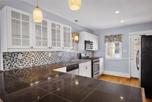 a kitchen with granite countertop a stove a sink and a refrigerator