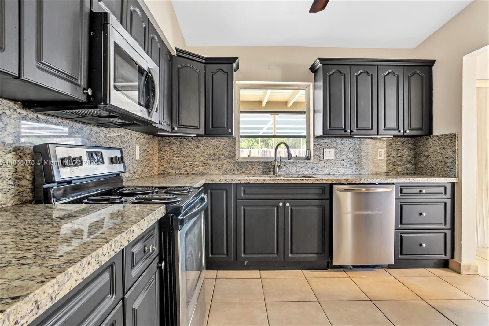 650 Northeast 178th Street Miami, FL 33162 - Photo 13 of 37 a kitchen with stainless steel appliances granite countertop a sink stove and cabinets