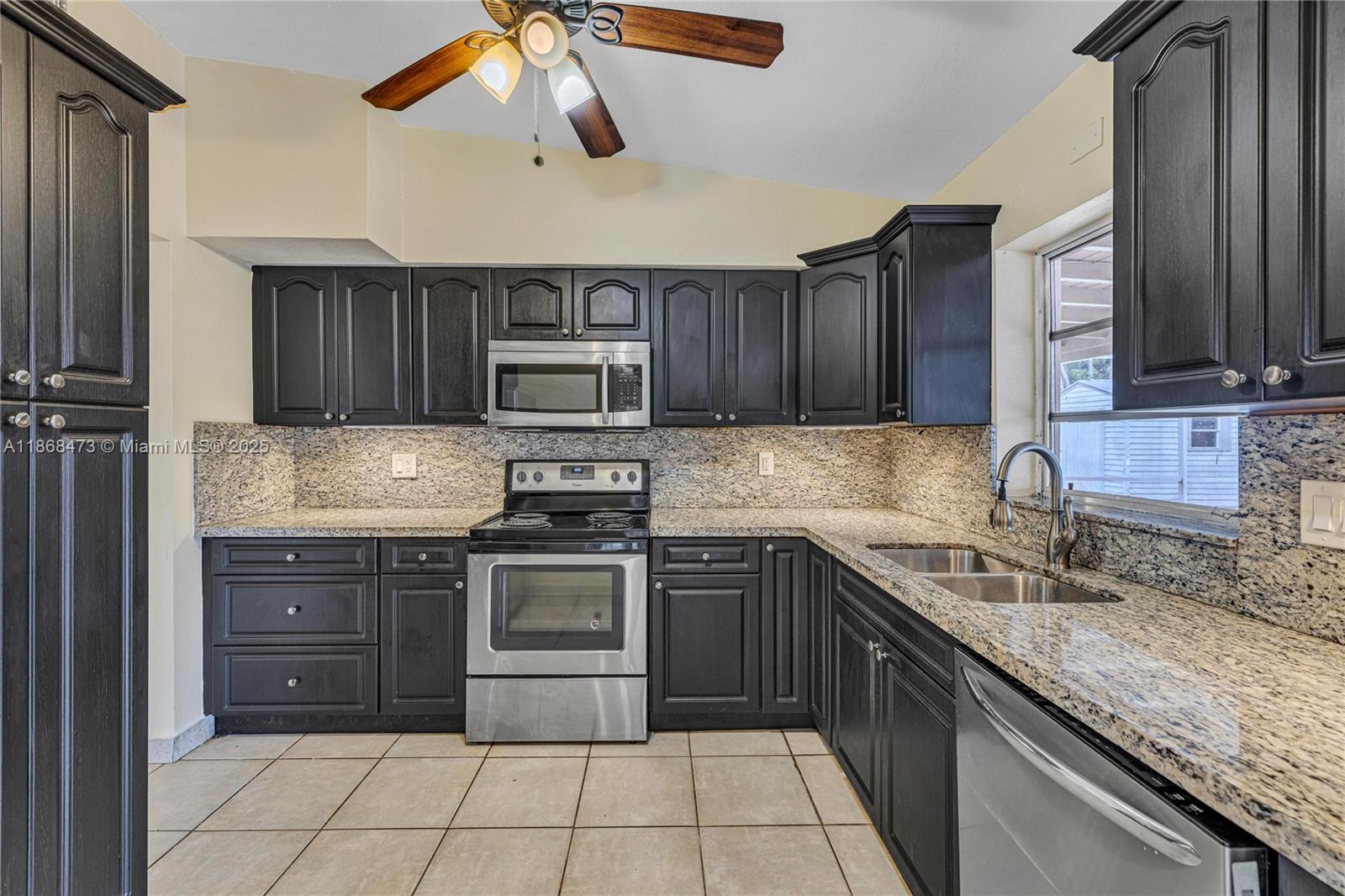 650 Northeast 178th Street Miami, FL 33162 - Photo 16 of 37 a kitchen with stainless steel appliances granite countertop a sink and stove top oven