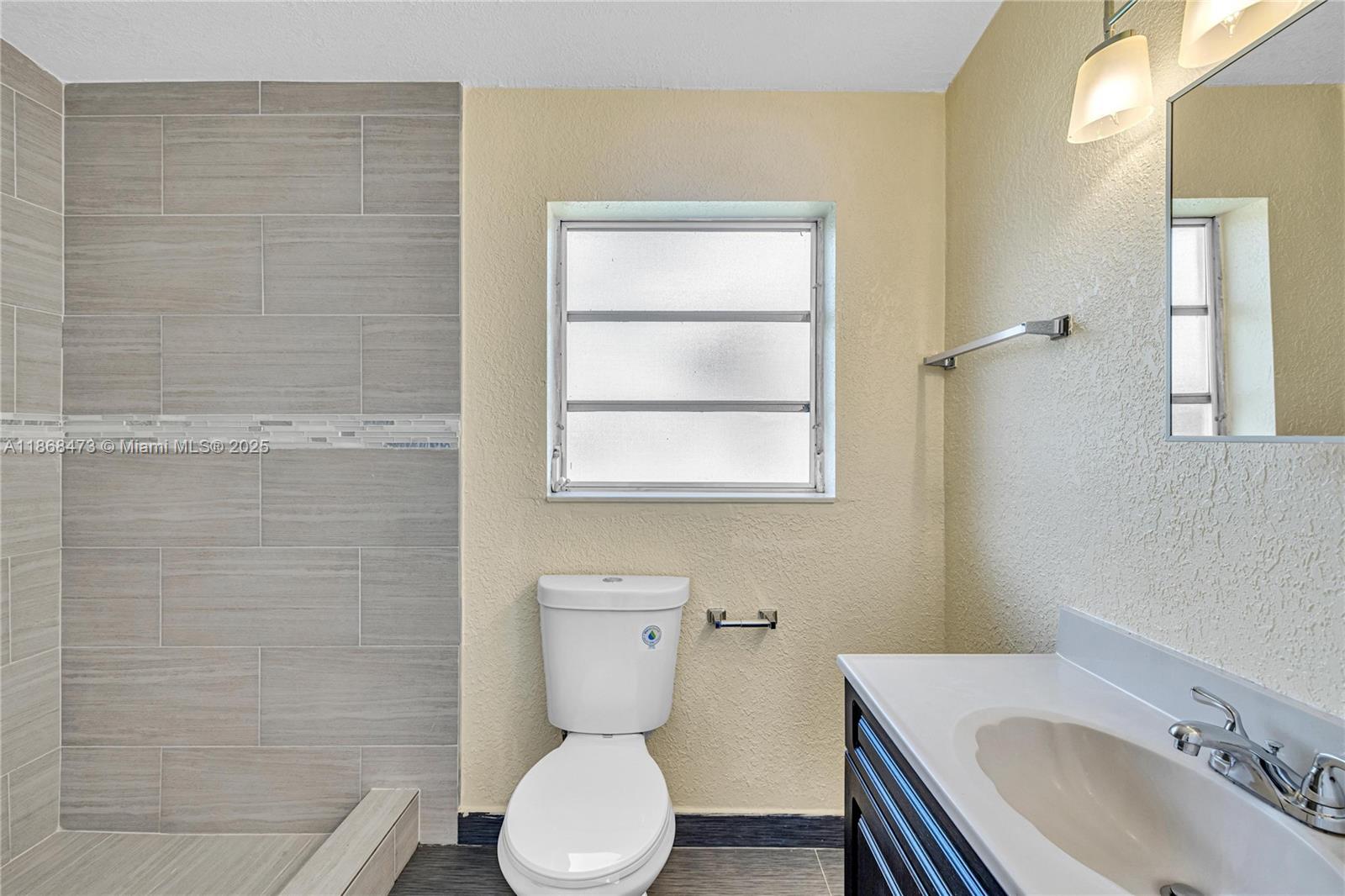 650 Northeast 178th Street Miami, FL 33162 - Photo 22 of 37 a bathroom with a sink a toilet and a mirror