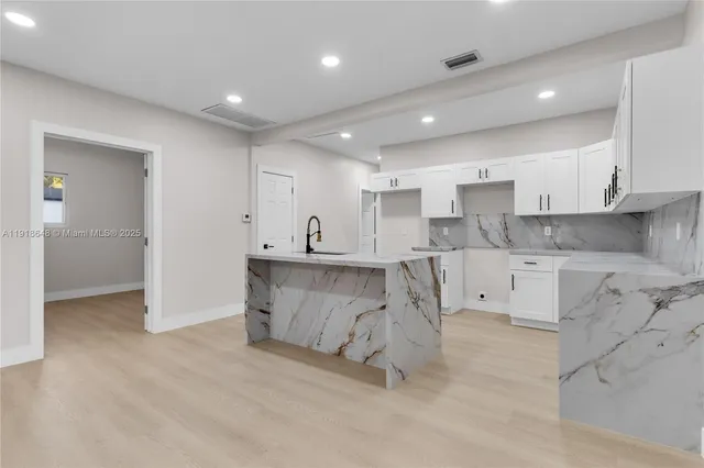 a kitchen with stainless steel appliances kitchen island granite countertop a sink and cabinets