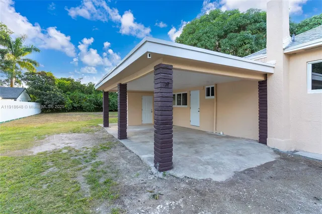 a view of a house with backyard and a tree