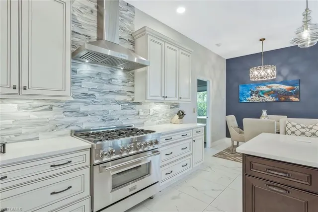 a kitchen with stainless steel appliances white cabinets and a stove top oven