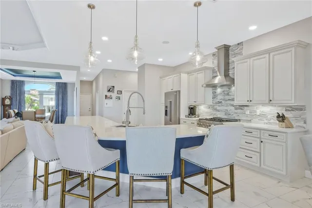 a kitchen with kitchen island a dining table chairs and white cabinets