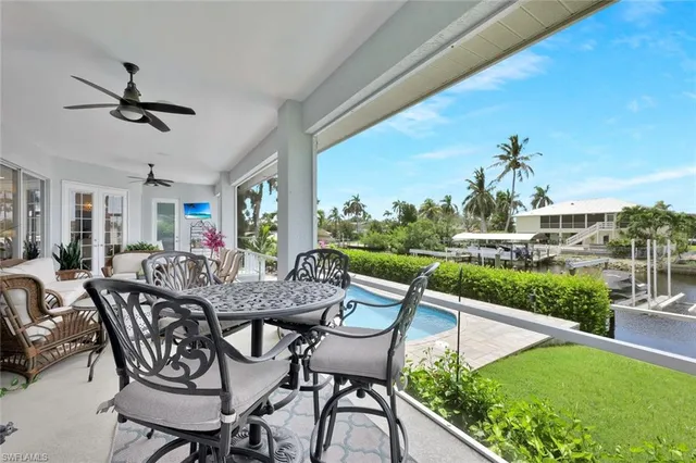 a view of a chairs and table in patio with a swimming pool