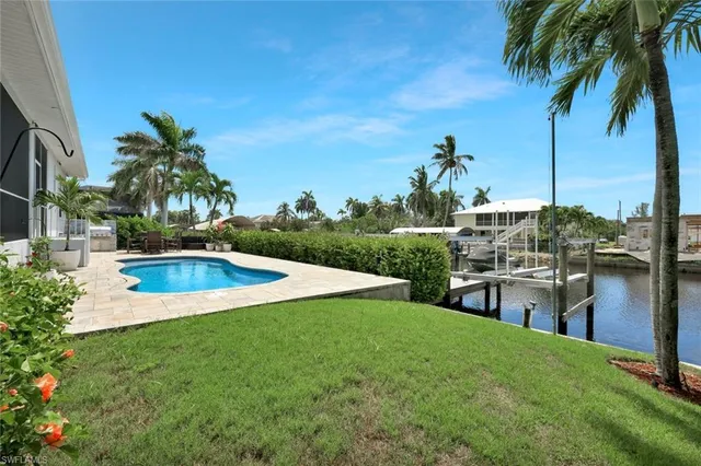 a swimming pool with outdoor seating and yard
