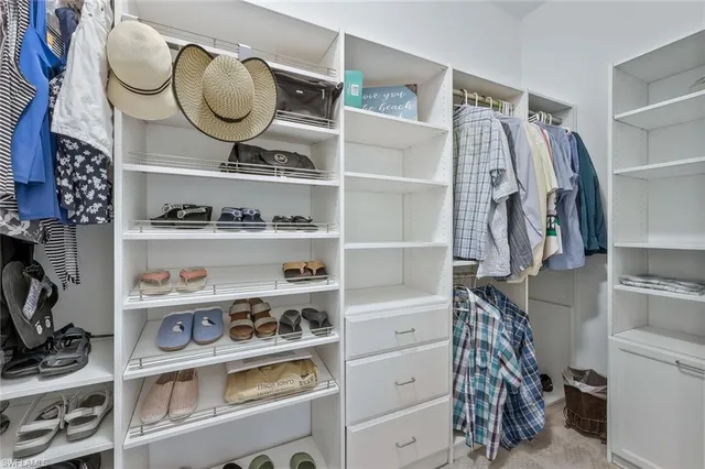 a view of walk in closet with clothes and shoes