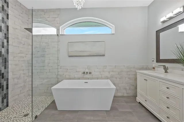 a bathroom with a double vanity sink mirror and bathtub