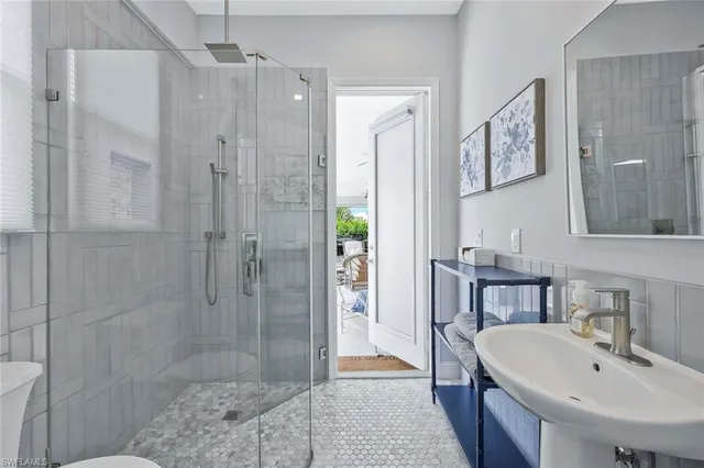 a bathroom with a shower a sink and a mirror