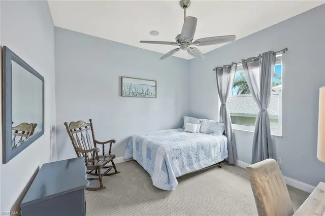 a bedroom with a bed chairs and a window