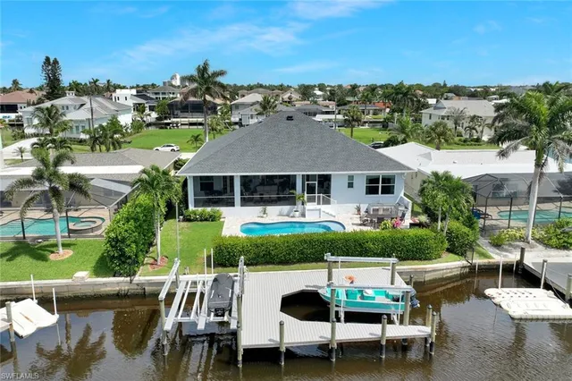 a view of a patio with couches table and chairs under an umbrella