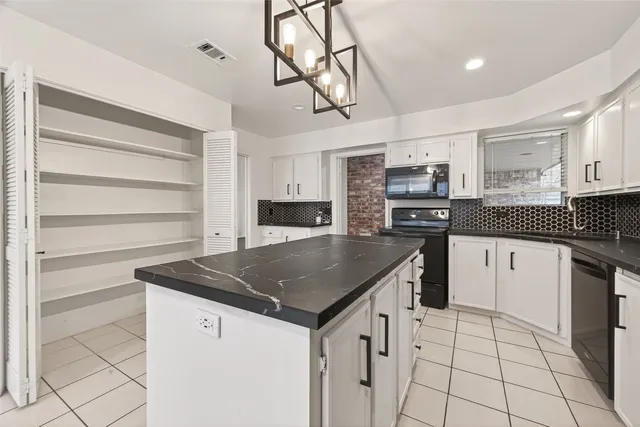 a kitchen with stainless steel appliances kitchen island granite countertop a sink a stove and cabinets