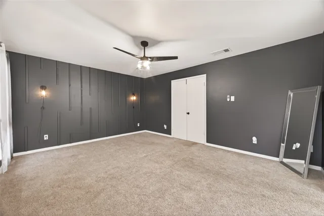 a view of an empty room with a ceiling fan