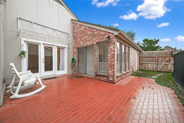 a view of backyard with large trees and wooden fence