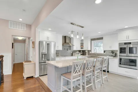 a kitchen with stainless steel appliances kitchen island granite countertop a refrigerator and a stove top oven