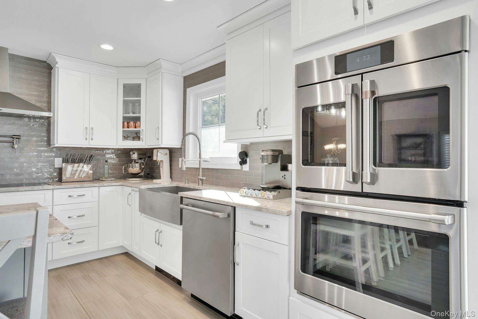 108 Hayrick Lane Commack, NY 11725 - Photo 14 of 50 a kitchen with a stove white cabinets sink and refrigerator