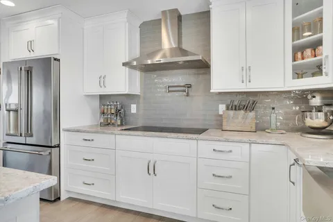 a kitchen with white cabinets and refrigerator