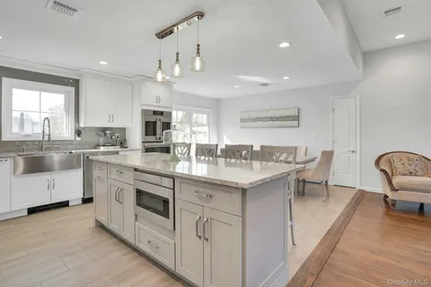 a large kitchen with stainless steel appliances granite countertop a sink refrigerator and cabinets