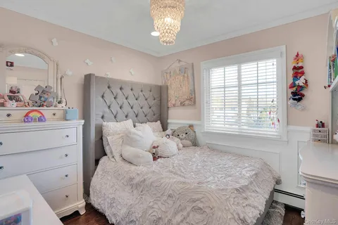 a bedroom with a bed dresser and flat screen tv