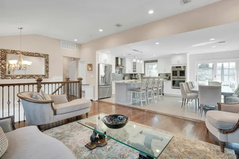 a living room with lots of furniture and a view of kitchen