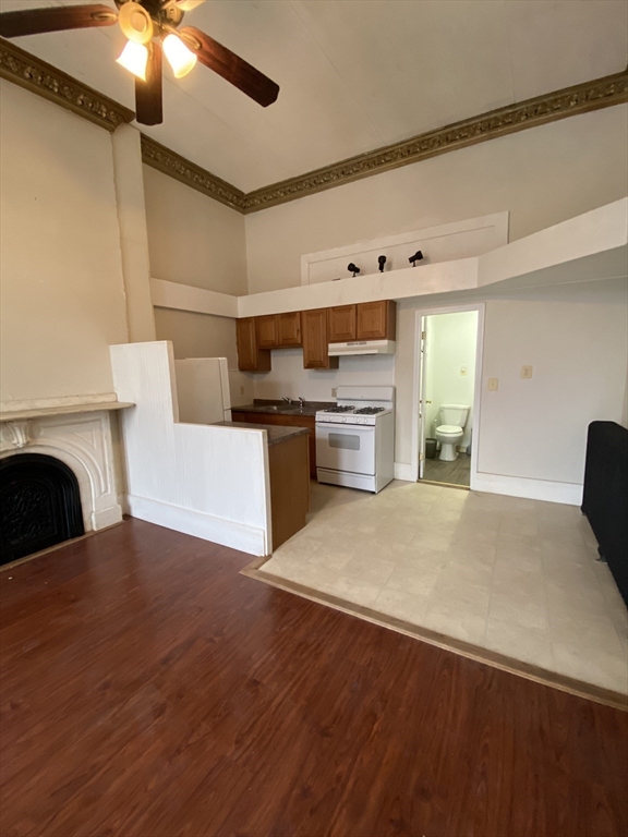a living room with stainless steel appliances furniture a fireplace and a flat screen tv