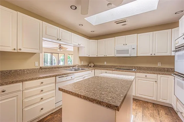 a kitchen with a sink and a stove top oven with wooden floor