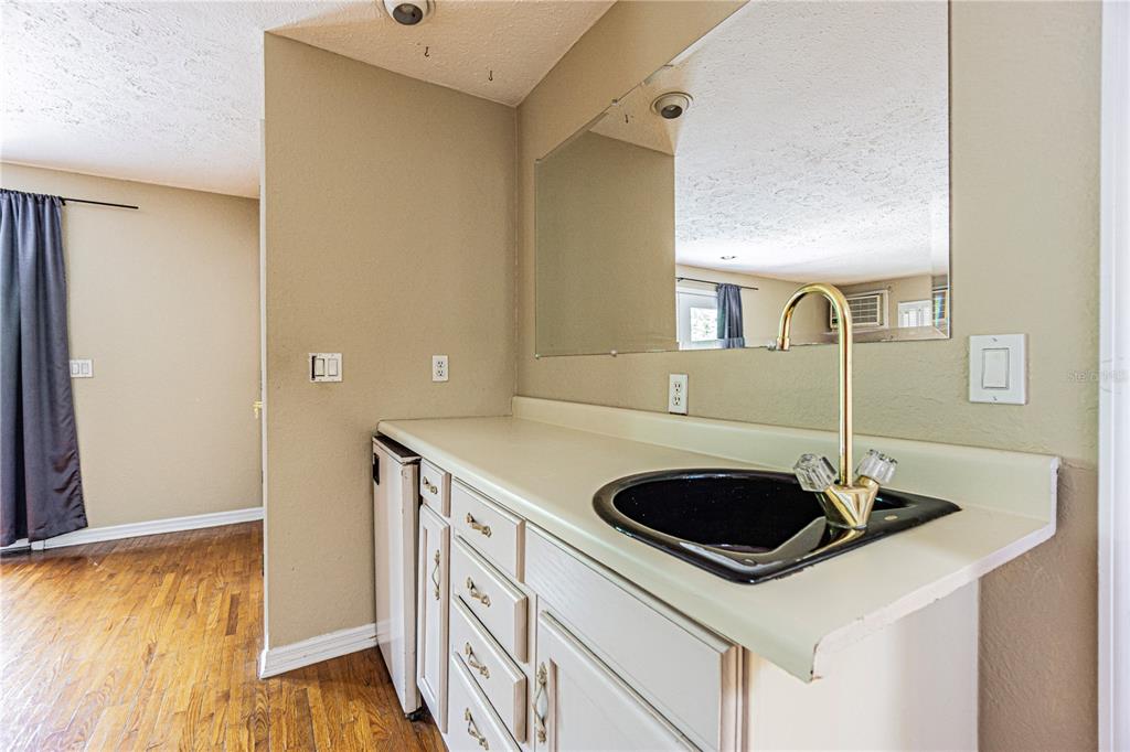 18129 Crawley Road, Unit 1 Odessa, FL 33556 - Photo 38 of 51 a kitchen with a sink and a stove top oven with wooden floor