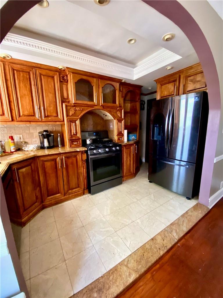 169-10 29th Avenue Queens, NY 11358 - Photo 4 of 10 a kitchen with stainless steel appliances granite countertop a refrigerator a stove and a sink with wooden floors