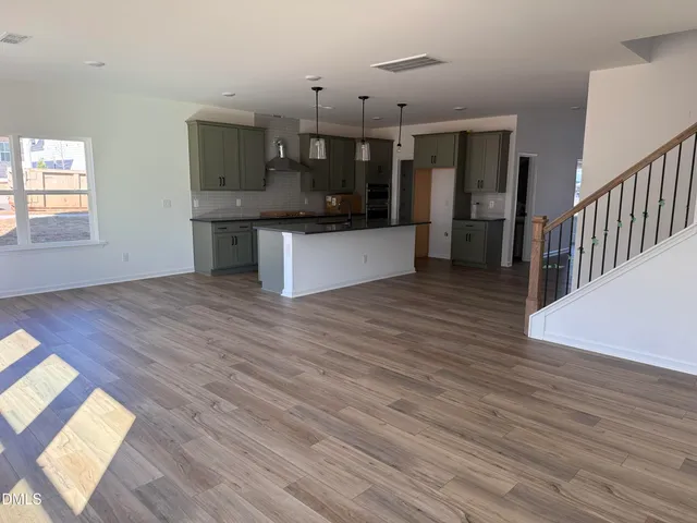 a large kitchen with stainless steel appliances wooden floors and large window