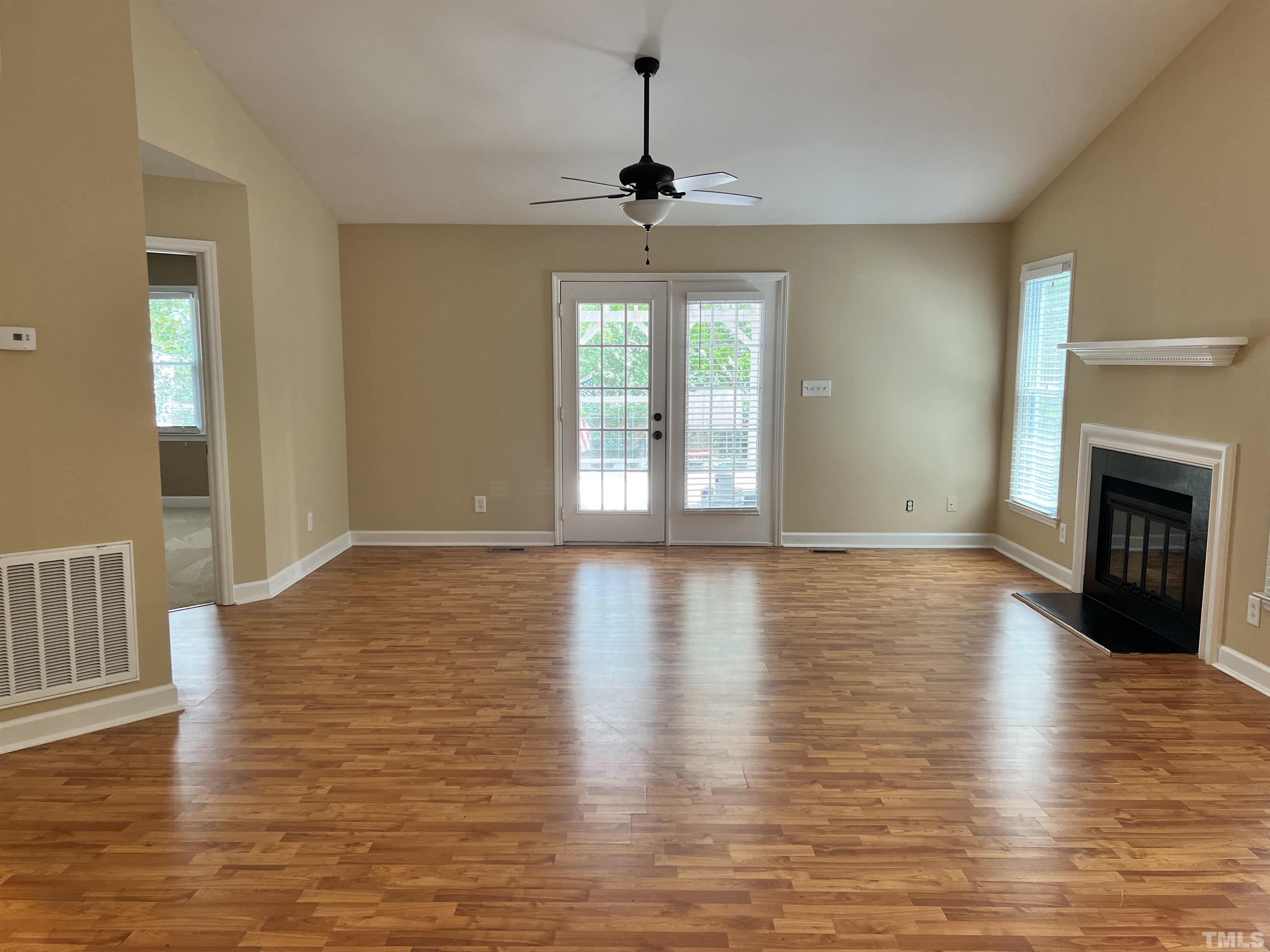 5612 Spring Pines Way Raleigh, NC 27616 - Photo 4 of 31 a view of an empty room with wooden floor fireplace and a window