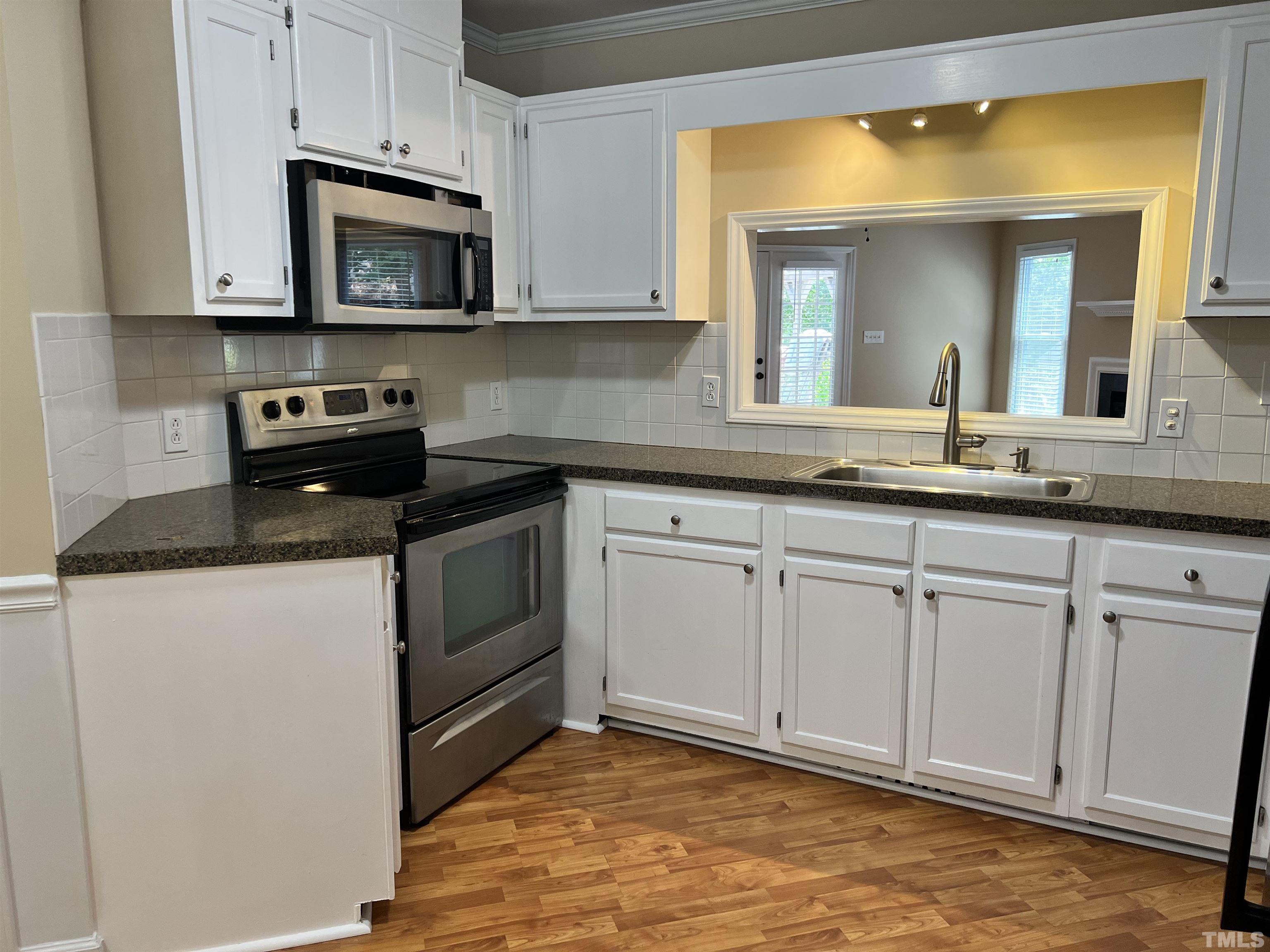 5612 Spring Pines Way Raleigh, NC 27616 - Photo 8 of 31 a kitchen with granite countertop white cabinets and stainless steel appliances