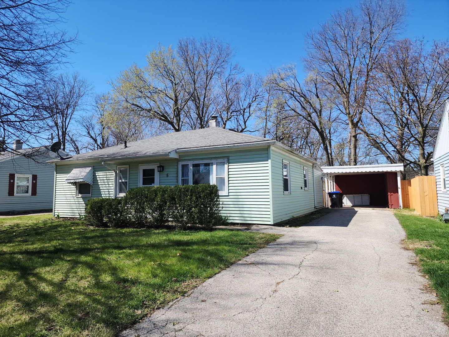 a front view of a house with a garden and trees