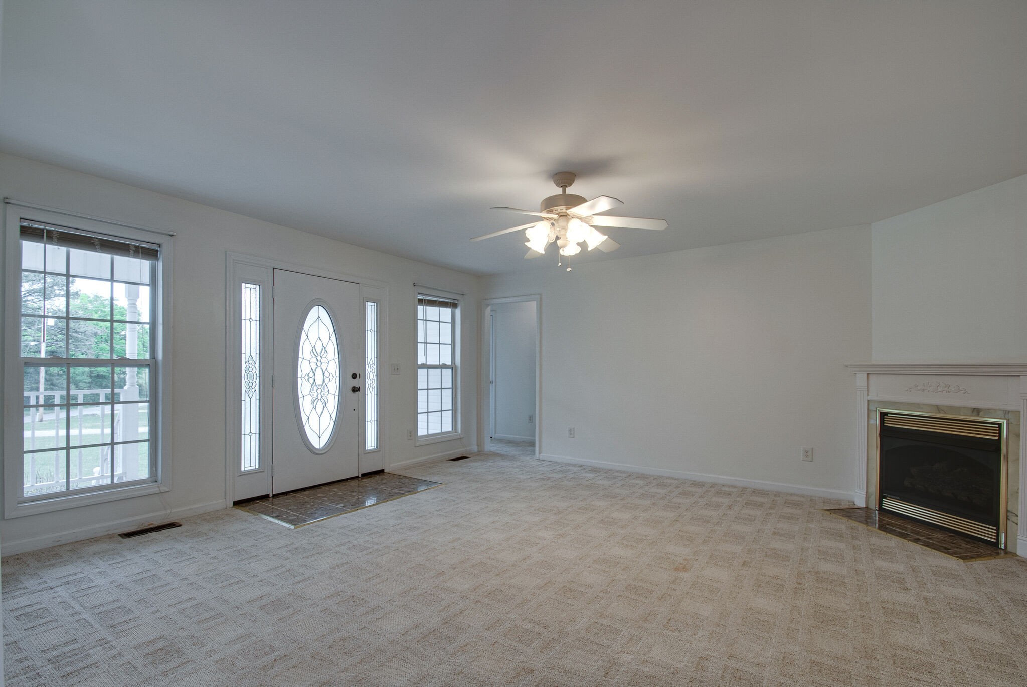 166 Caldwell Road Summertown, TN 38483 - Photo 5 of 36 an empty room with chandelier fan and fireplace