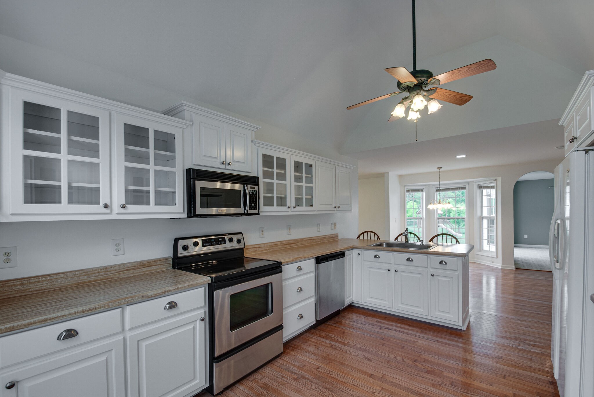 166 Caldwell Road Summertown, TN 38483 - Photo 6 of 36 a kitchen with stainless steel appliances granite countertop a sink a stove top oven a refrigerator with wooden floors and cabinets