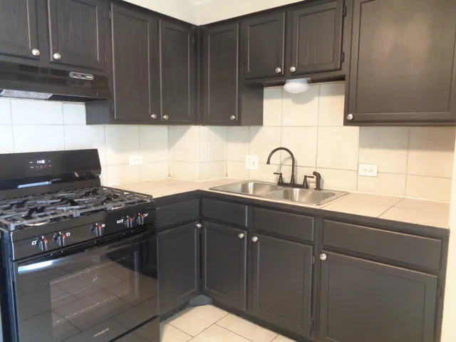 a kitchen with wooden cabinets and a stove top oven