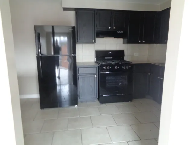 a kitchen with a refrigerator and cabinets