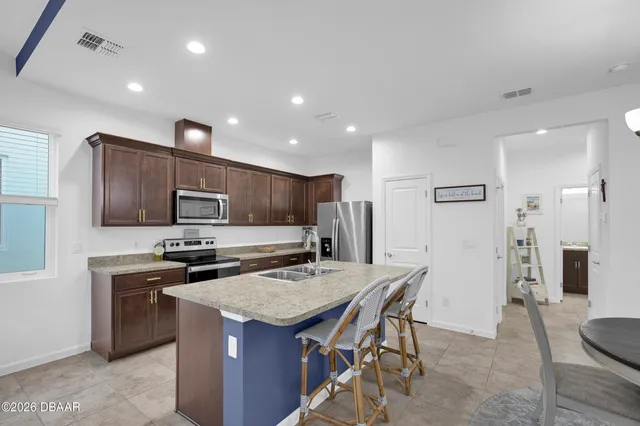 a kitchen with stainless steel appliances a stove a sink a refrigerator and cabinets