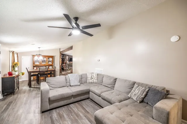a living room with furniture and a wooden floor