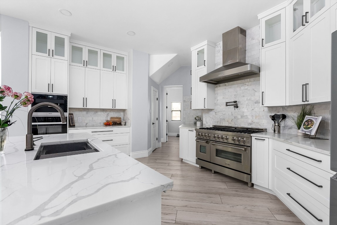 Custom remodeled kitchen with quartz countertops, high end appliances, ample cabinetry and custom spaces for separate wine bar and coffee bar stations