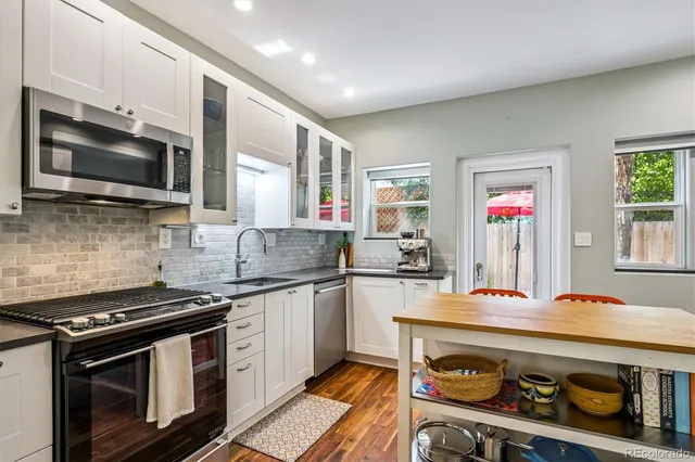 a kitchen with stainless steel appliances a stove microwave and sink