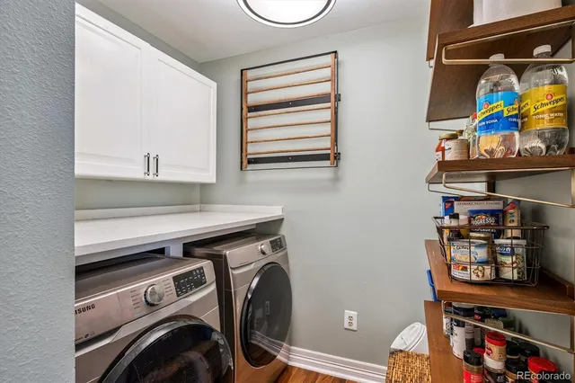 a utility room with dryer washer and a view of living room