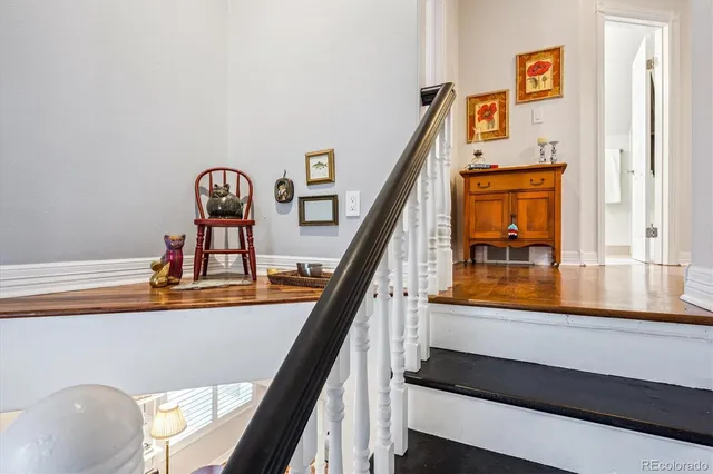 a view of a hallway with wooden floor and stairs
