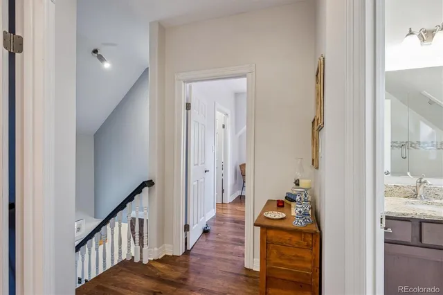 a view of a hallway with dining room and wooden floor